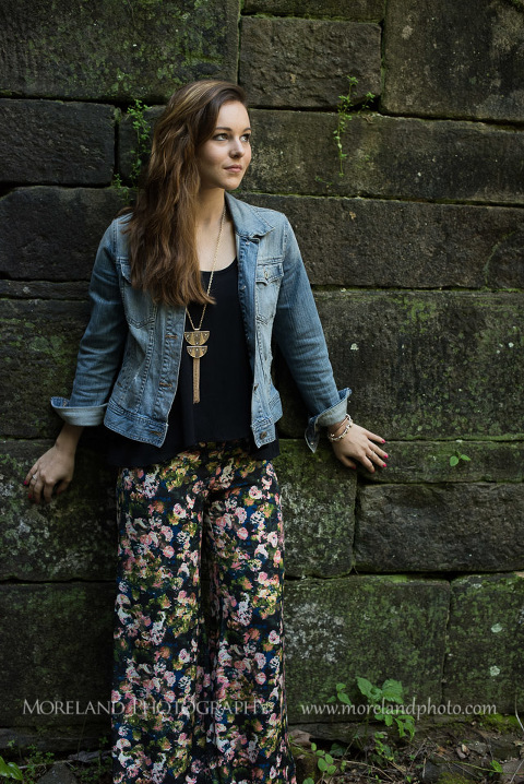 mikemoreland, morelandphoto, edgy, outdoors, medium close-up, soft lighting, slight smile, floral pants, standing against wall