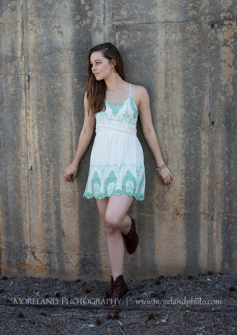 mikemoreland, morelandphotography, edgy, urban, outdoors, soft lighting, leaning on a wall, looking away, white dress with blue pattern, black boots