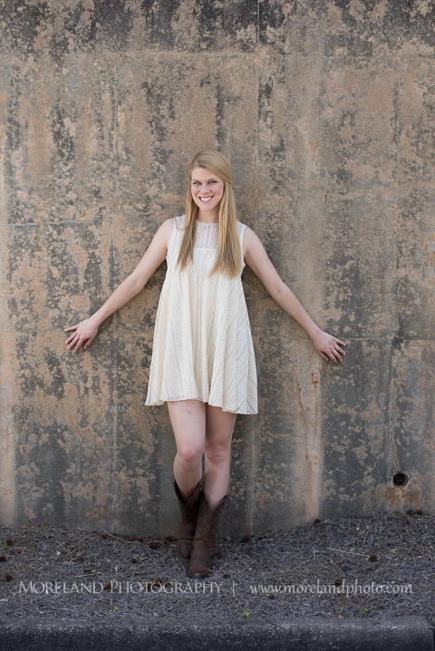 mikemoreland, morelandphoto, sweet, girly, outdoors, long shot, soft lighting,leaning on a wall, big smile, white dress, boots