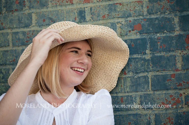 High school senior smiling while holding her hat to her head, Roswell Senior Photography, Atlanta Senior Portraits, Senior Photography, Atlanta Senior Photography, Moreland Photography, Mike Moreland, Class of 2016, mikemoreland, morelandphoto, excitement, class of 2016, country girl, sparkling future, big grin, white blouse, close-up portrait, strawhat