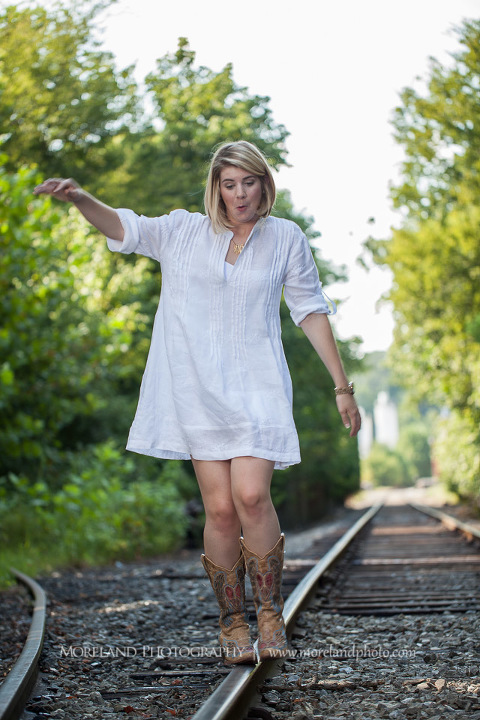 High school senior walking along abandoned railroad tracks, Roswell Senior Photography, Atlanta Senior Portraits, Senior Photography, Atlanta Senior Photography, Moreland Photography, Mike Moreland, Class of 2016, mikemoreland, morelandphoto, excitement, class of 2016, country girl, sparkling future, big grin, posing by train tracks, white blouse, model portrait, afternoon, cowgirl boots, walking the railroad, silly face, balance posing