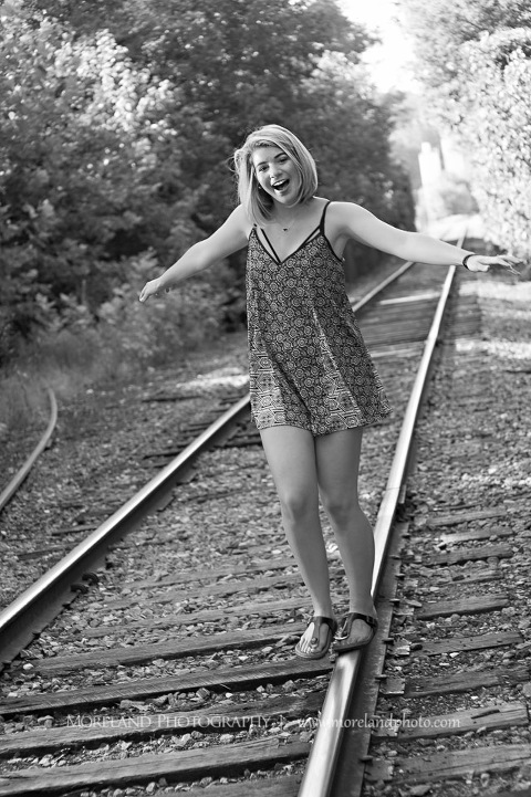 Gray scale of high school senior walking along abandoned railroad tracks, Roswell Senior Photography, Atlanta Senior Portraits, Senior Photography, Atlanta Senior Photography, Moreland Photography, Mike Moreland, Class of 2016, mikemoreland, morelandphoto, excitement, class of 2016, country girl, sparkling future, big grin, posing by train tracks, mixed color blouse, model portrait, afternoon, black and white photography, having fun, playing on the railroad