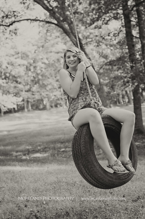 High school senior on a tire swing smiling, Roswell Senior Photography, Atlanta Senior Portraits, Senior Photography, Atlanta Senior Photography, Moreland Photography, Mike Moreland, Class of 2016, mikemoreland, morelandphoto, excitement, class of 2016, country girl, sparkling future, big grin, mixed color blouse, model portrait, afternoon, black and white photography, having fun, playing on the tire swing
