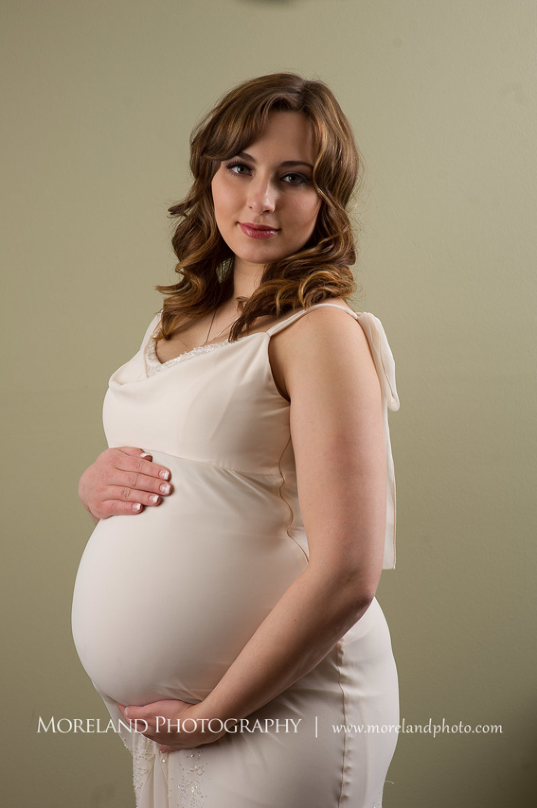 Pregnant woman standing while holding her stomach, beautiful, serene, love, joy, happiness, classic, timeless