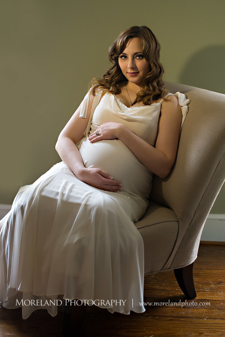 Pregnant woman is holding her stomach while sitting down, beautiful, serene, love, joy, happiness, classic, timeless
