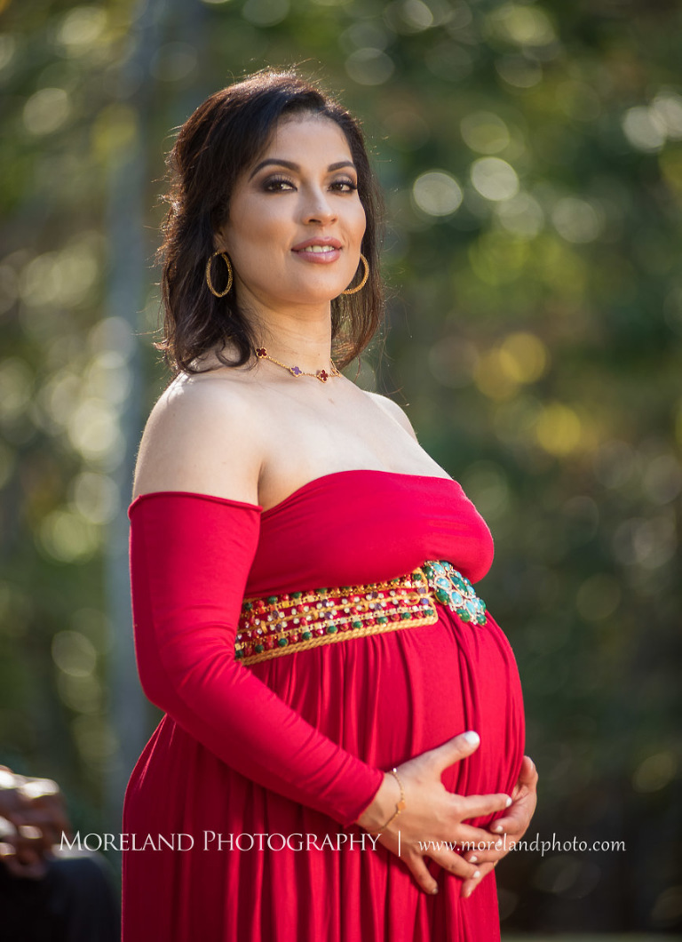 Elegant pregnant woman in sophisticated red maternity dress cradling belly outside, pregnancy, romantic pregnancy photo shoot, outdoor maternity photo shoot, red maternity dress, Atlanta area photography, Atlanta area maternity photographers, fashion maternity shoots, regal estates for photos, mike moreland photography 