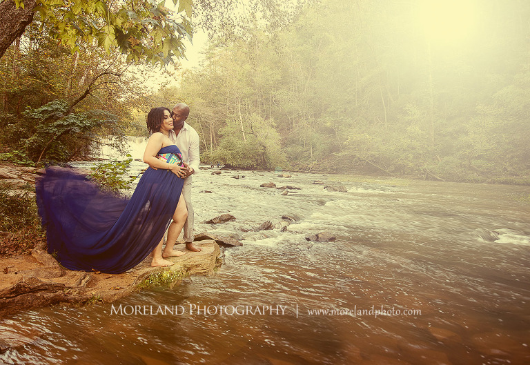 Brightened image of Interracial couple having a romantic moment standing on a rock next to a flowing river,pregnancy, interracial couple, outdoor pregnancy photo shoots, maternity shoots with nature, romantic pregnancy photo shoot, purple maternity dress, outdoor maternity photo shoot, romantic moment, maternity shoots with water, fun maternity shoots, romantic photo shoot, Atlanta area photography, Atlanta area maternity photographers, fashion maternity shoots, mike moreland photography 