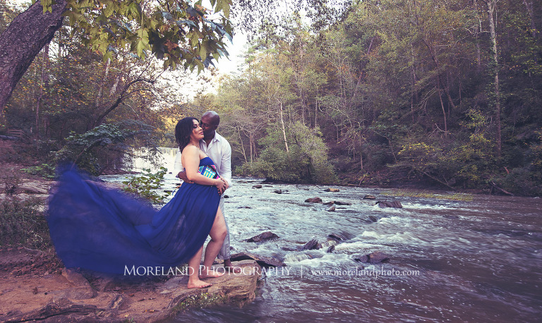 Interracial couple having a romantic moment standing on a rock next to a flowing river,pregnancy, interracial couple, outdoor pregnancy photo shoots, maternity shoots with nature, romantic pregnancy photo shoot, purple maternity dress, outdoor maternity photo shoot, romantic moment, maternity shoots with water, fun maternity shoots, romantic photo shoot, Atlanta area photography, Atlanta area maternity photographers, fashion maternity shoots, mike moreland photography 