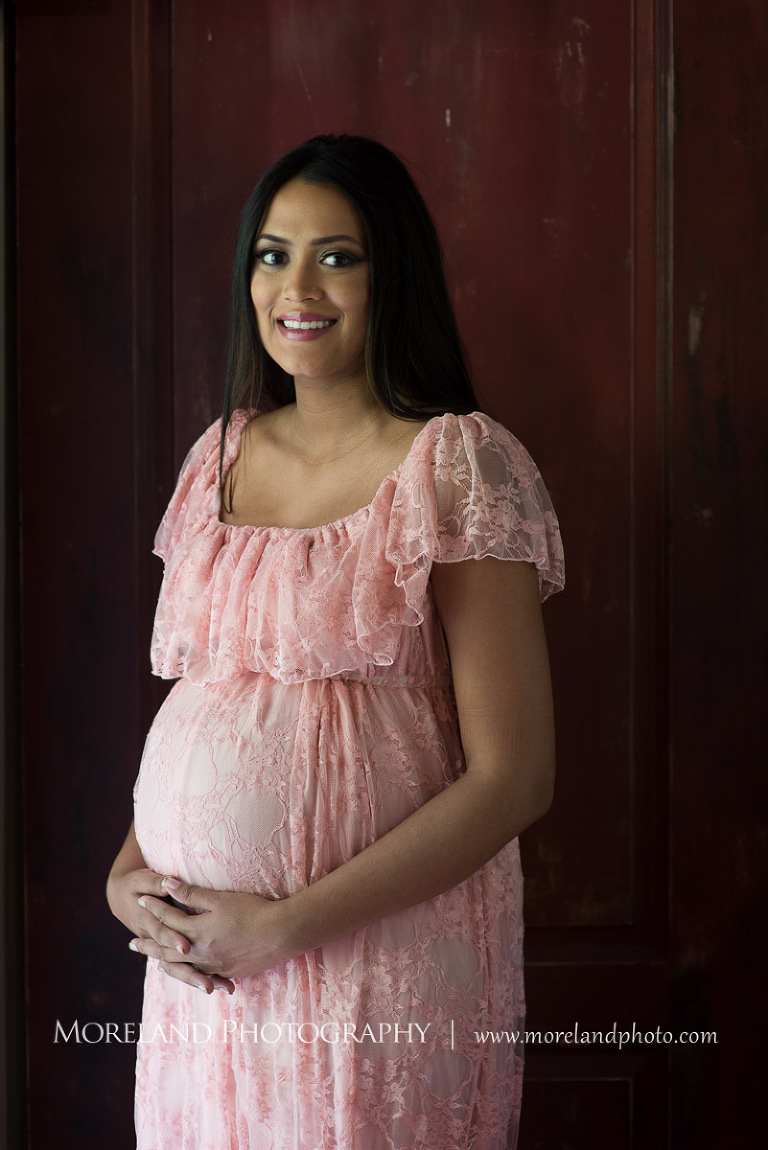 Indian woman holding her pregnant belly while looking into the camera, beautiful, peaceful, happy, joy, expecting, baby, pregnant