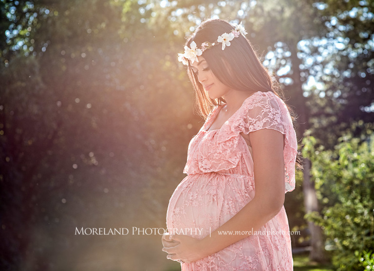 Pregnant Indian woman looking down at her stomach while holding her stomach, outdoor maternity, naturalistic maternity, beautiful, love, adoration, nature, natural, joy, romance, peaceful, protection, serene