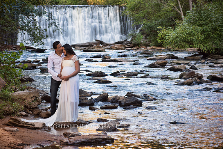 Indian husband holding his pregnant wife by a waterfall, naturalistic maternity, beautiful, love, adoration, nature, natural, joy, romance, peaceful, protection, serene