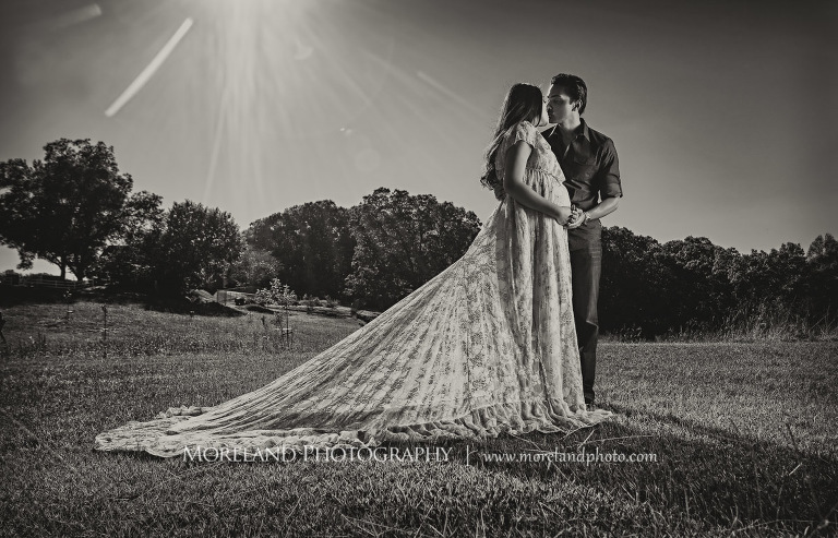 Gray scale image of Indian husband sharing an intimate moment with his pregnant wife in an open field on a sunny day, love, peaceful, beautiful, joy, happiness, expecting