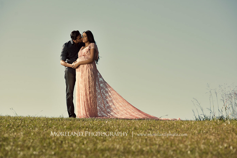 Pregnant wife in the arms of her husband in an open meadow, love, adoration, nature, natural, joy, romance, peaceful, protection, serene