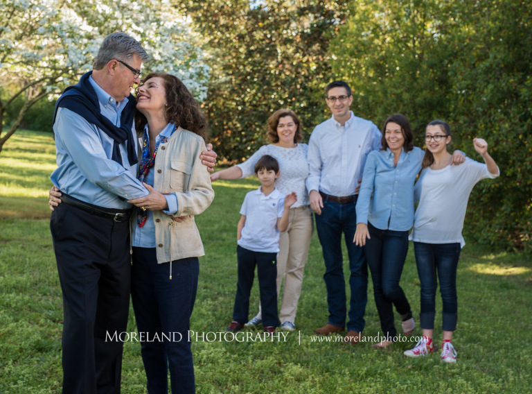 Family portarit of six standing outside in the daytime with the main focus being the grandparents holding each other in front of the rest of the family, Atlanta Portrait Photographer, Atlanta Child Photographer, Atlanta Family Photographer, Moreland Photography, Mike Moreland