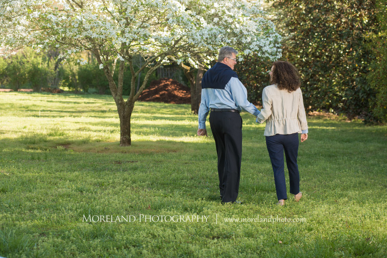Portrait of a couple smiling and walking off into the distance towards a white flowery tree outside during the daytime, Atlanta Portrait Photographer, Atlanta Child Photographer, Atlanta Family Photographer, Moreland Photography, Mike Moreland