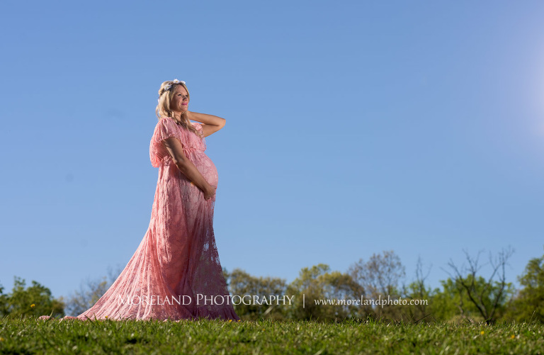 Pregnant woman standing in a field in a pink dress as she holds her stomach, Atlanta Maternity Photographer, Maternity Photos Atlanta, Georgia Maternity Photography, Moreland Photography, Mike Moreland, Outdoor Maternity, Maternity on the River, 