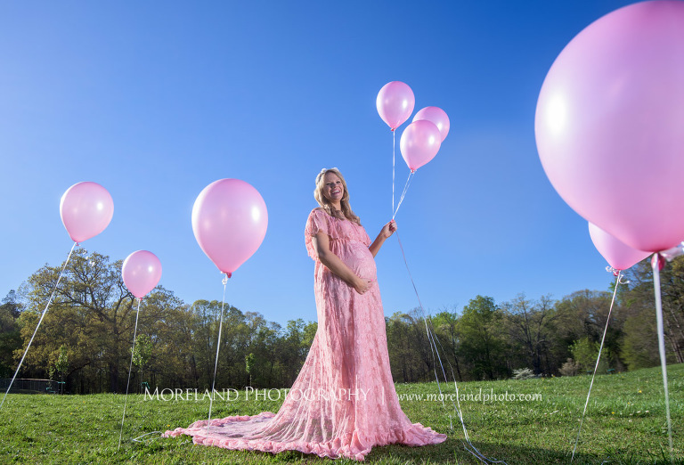 Pregnant woman wearing a pink lace dress holds pink balloons as she touches her belly, Atlanta Maternity Photographer, Maternity Photos Atlanta, Georgia Maternity Photography, Moreland Photography, Mike Moreland, Outdoor Maternity, Maternity on the River, 