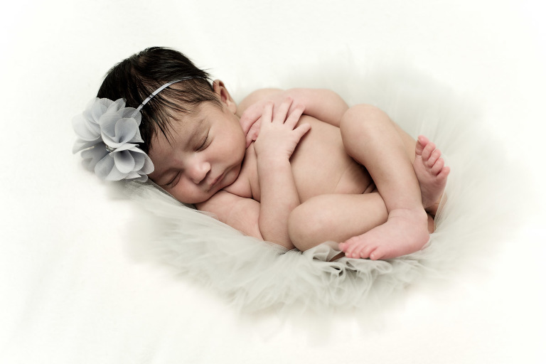 Newborn baby girl curled up asleep with a flower head piece on, bundle of joy, newborn, little angel, tot, girl, kid, buttercup, innocent, happiness