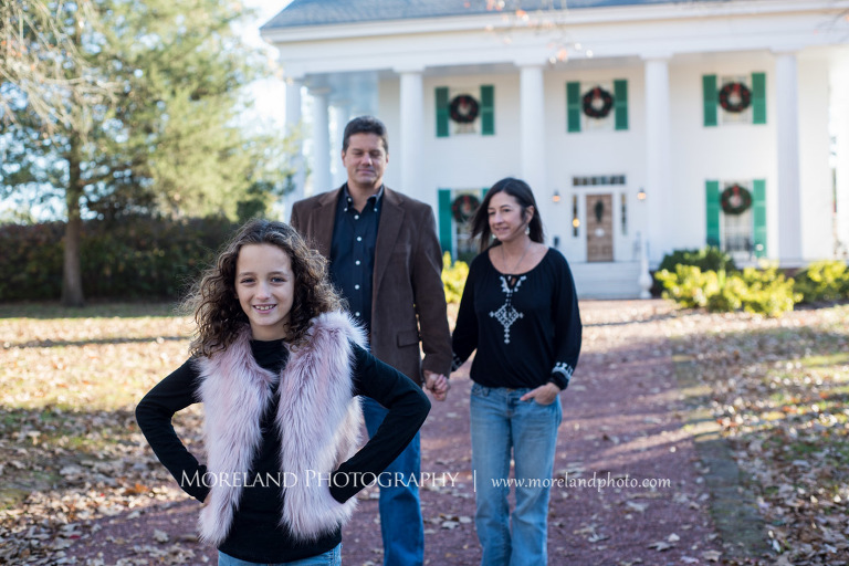 Portrait of family of three standing in front white house during the daytime with little girl being the main focu with parents behind her, Family Moments, Atlanta Portrait Photographer, Atlanta Child Photographer, Atlanta Family Photographer, Moreland Photography, Mike Moreland