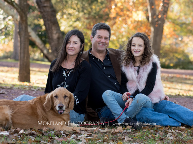 Portrait of family of three and dog sitting in the grass surrounded by trees outside during the fall season, Atlanta Portrait Photographer, Atlanta Child Photographer, Atlanta Family Photographer, Moreland Photography, Mike Moreland