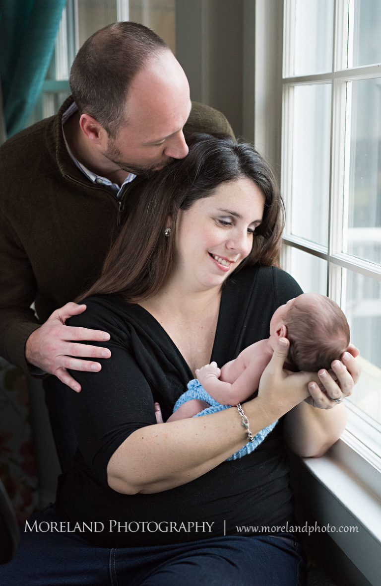 A mother holding her newborn son close whole standing next to a window as her husband kisses her forehead, Atlanta Newborn Photography, Newborn Photographer Atlanta, Birth Photography, Natural Birth Photography, Hospital Photographer, Moreland Photography, Mike Moreland