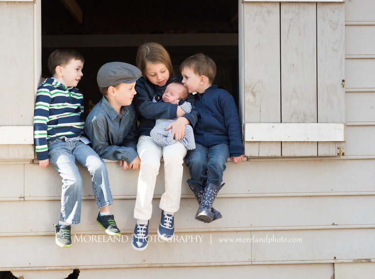 Four siblings sitting in the window sill of a barn while holding and looking at their newborn baby brother, Family Newborn Photography, Atlanta Newborn Photography, Newborn Photographer Atlanta, Birth Photography, Natural Birth Photography, Hospital Photographer, Moreland Photography, Mike Moreland