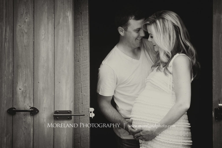 Black and white portrait of pregnant couple smiling at each other standing in the door of a barn,Maternity Photography, Atlanta Maternity, Lifestyle Maternity Photography, Styled Maternity Shoot, Moreland Photography, Mike Moreland, Outdoor Maternity, Nature Maternity, 