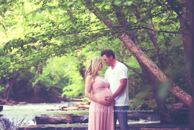 outdoor maternity shoot, Portrait of pregnant couple looking at each other holding wife's belly standing outside surrounded by trees, Maternity Photography, Atlanta Maternity, Lifestyle Maternity Photography, Styled Maternity Shoot, Moreland Photography, Mike Moreland, Outdoor Maternity, Nature Maternity, 