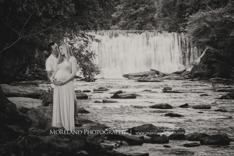 Black and white portrait of pregnant couple holding each other standing in front of a waterfall, Maternity Photography, Atlanta Maternity, Lifestyle Maternity Photography, Styled Maternity Shoot, Moreland Photography, Mike Moreland, Outdoor Maternity, Nature Maternity, 