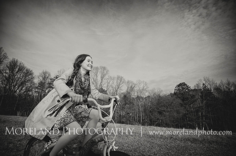 girl laughing and biking through field, Childen Ballet, Child Portraits, Atlanta Photgraphy, Moreland Photography, Roswell Portraits, ballet shoes, dancer, bicycle, black and white,