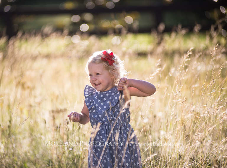 little girl in polka dot dress smiling in a field, Mike Moreland, Moreland Photography, wedding photography, Atlanta wedding photography, detailed wedding photography, lifestyle wedding photography, Atlanta wedding photographer,