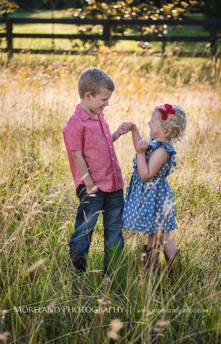 boy in red button down holding hands with sister in polka dot dress in a field, Woodstock Photographer, Mike Moreland, Moreland Photography, wedding photography, Atlanta wedding photography, detailed wedding photography, lifestyle wedding photography, Atlanta wedding photographer,