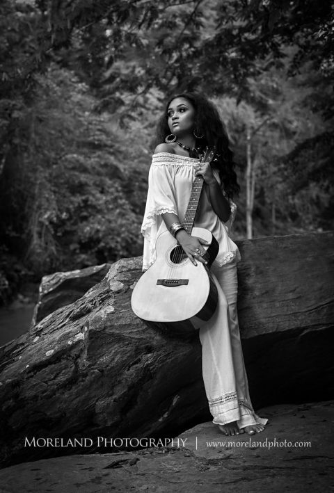 black and white senior, black and white senior playing guitar on rock in forest, black and white outdoor senior photography, black and white elegant senior playing guitar outdoors on rock near river, Atlanta Senior Portrait Photographer, Senior Portrait, Beautiful Girl, Long Haired Black Woman, Beauty, Elegant Senior Photo Shoot, Senior Shoot, Mike Moreland, Moreland Photography, wedding photography, Atlanta wedding photography, detailed wedding photography, lifestyle wedding photography, Atlanta wedding photographer,