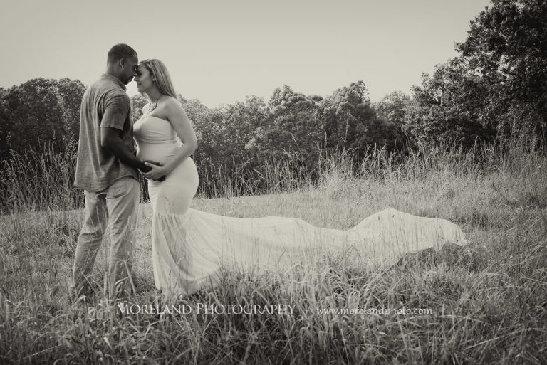 Black and white pregnant woman with husband standing in field wearing flowy maternity dress, spring maternity shoot, Mike Moreland, Moreland Photography, Atlanta Portrait Photographer, Maternity Photography Atlanta