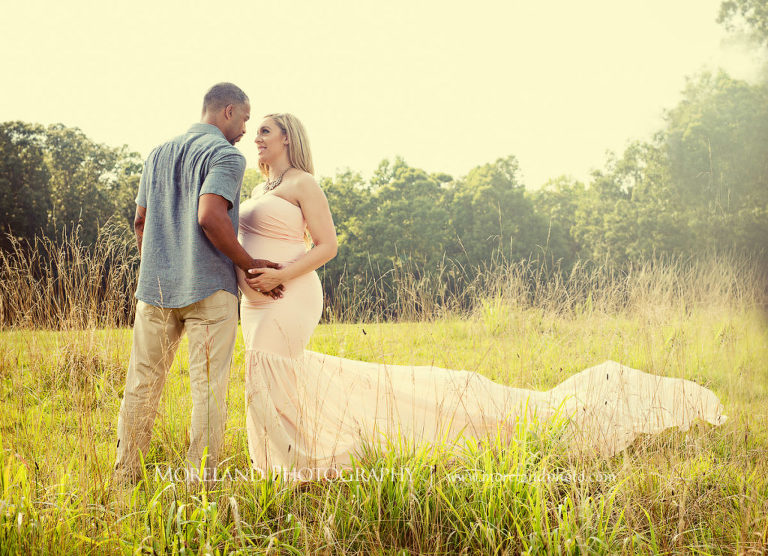 Pregnant woman with husband standing in field wearing pink, flowy maternity dress, Mike Moreland, Moreland Photography, Atlanta Portrait Photographer, Maternity Photography Atlanta