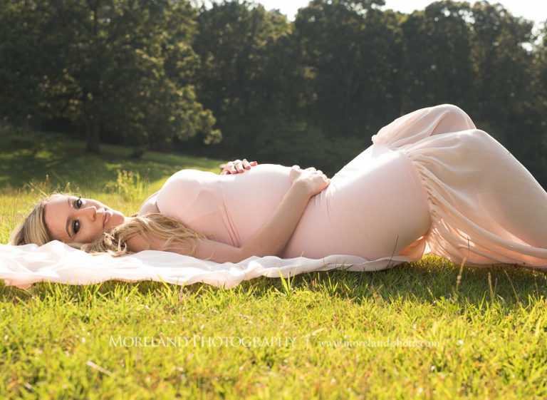 Pregnant woman laying in field wearing pink, flowy maternity dress, Mike Moreland, Moreland Photography, Atlanta Portrait Photographer, Maternity Photography Atlanta