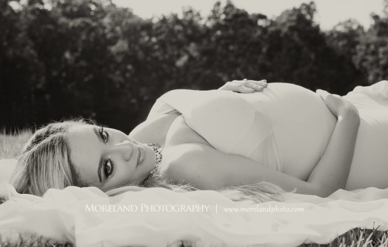 Black and white pregnant woman laying in field wearing pink, flowy maternity dress, Mike Moreland, Moreland Photography, Atlanta Portrait Photographer, Maternity Phorotography Atlanta