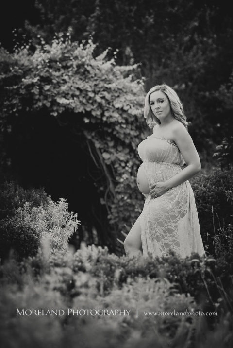 Black and white pregnant woman standing in English garden wearing pink, flowy maternity dress, Mike Moreland, Moreland Photography, Atlanta Portrait Photographer, Maternity Photography Atlanta