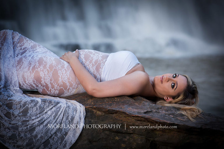 Pregnant woman laying on river rock wearing white, lacey maternity dress, spring maternity shoot, Mike Moreland, Moreland Photography, Atlanta Portrait Photographer, Maternity Photography Atlanta