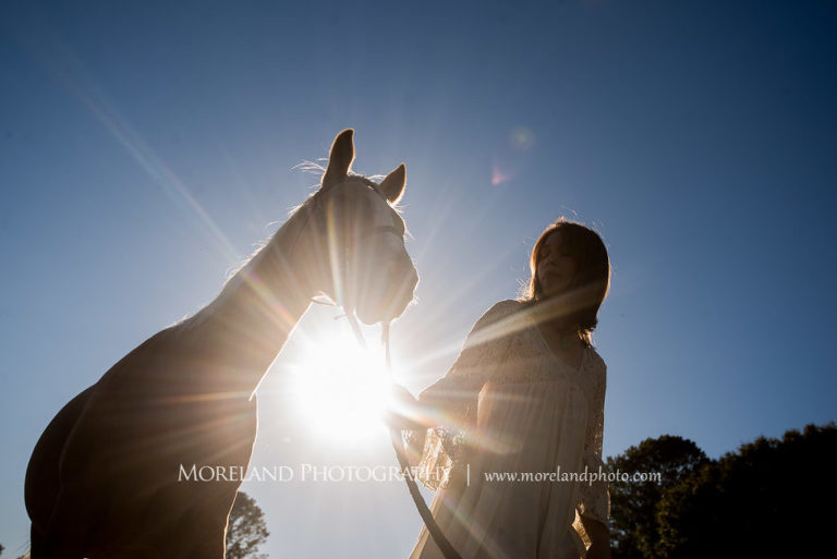 Georgia Senior portrait looking up at the sun peaking through a girl walking with her horse, Mike Moreland, Moreland Photography, Atlanta Portrait Photographer, Senior Photography Atlanta, Kings Ridge Christian Academy, Nature, Equestrian, Georgia Senior Portrait, Outdoors Photography, Georgia Girl, Walking Holding Reins, Horse Bridal, Horse, Girl And Horse, Sun, Afternoon, 