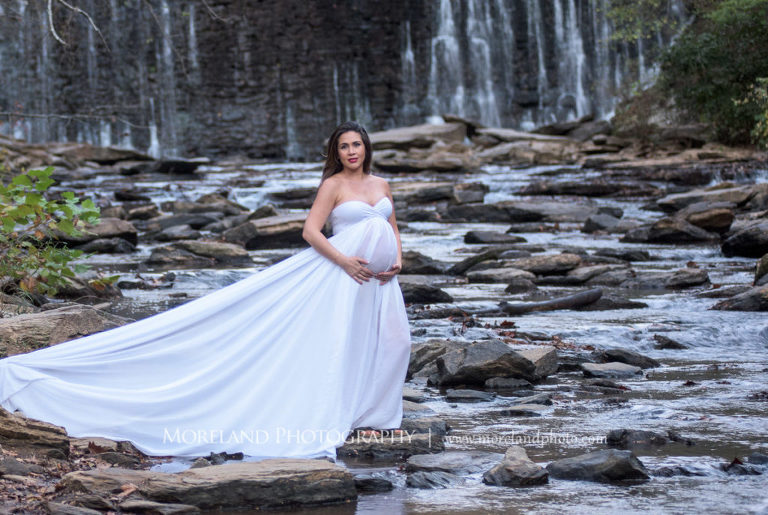 Maternity shoot of mother walking across large rocks in a flowing stream with waterfall in the background, Mike Moreland, Moreland Photography, Atlanta Portrait Photographer, Maternity Photography Atlanta, New Born Photography, New Born Photography Atlanta, Baby, Downtown Atlanta, Family, Mother, Waterfall, Outdoors Photography, White dress