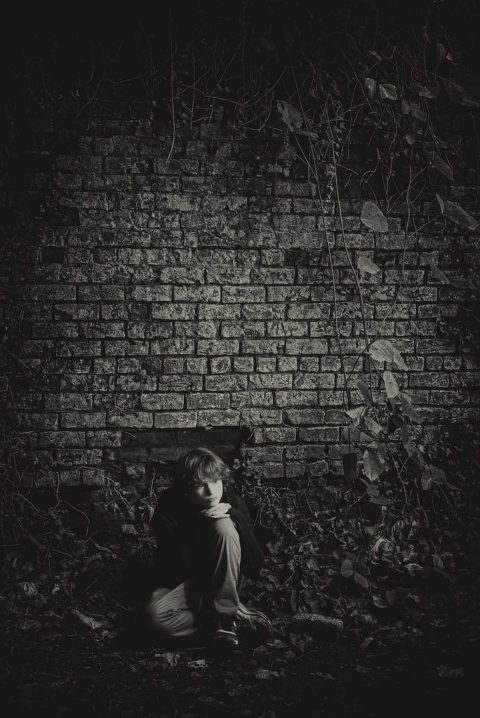 black and white image of teenage boy sitting by brick wall, black and white portrait, creative children photography, Atlanta portrait photographer, Moreland Photography