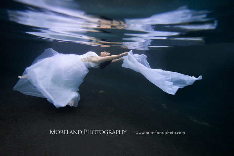 Woman in white dress laying flat holding out white sheet underwater, underwater pictures, creative photography atlanta, creative edge workshops, moreland photography, creative underwater photo shoot, underwater photography, nikon underwater, Georgia underwater photography, leading underwater photographer, artful photography, beautiful photo, underwater photo, elegant photography, Atlanta photography, Georgia underwater photography