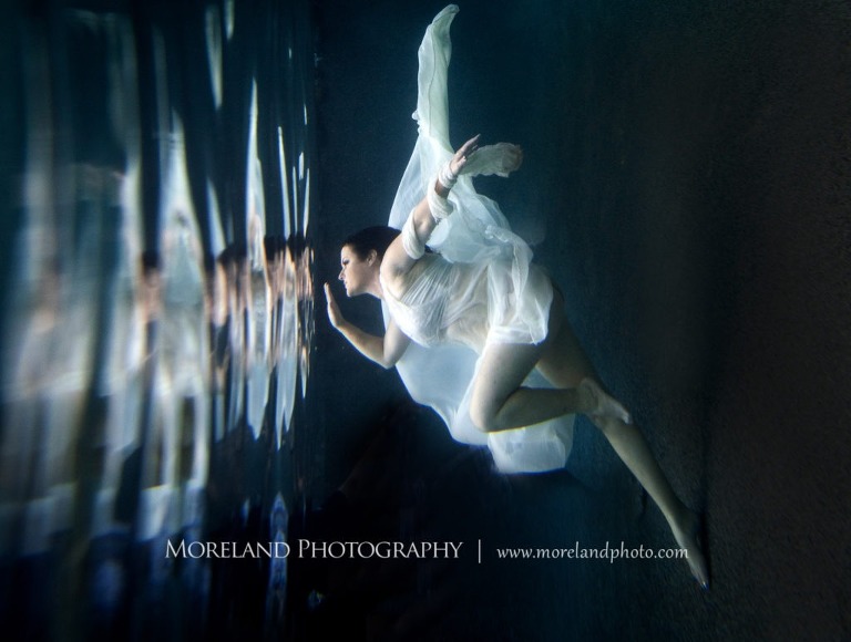 Woman pensively looking at reflection underwater in white dress, underwater pictures, creative photography atlanta, creative edge workshops, moreland photography, creative underwater photo shoot, underwater photography, nikon underwater, Georgia underwater photography, leading underwater photographer