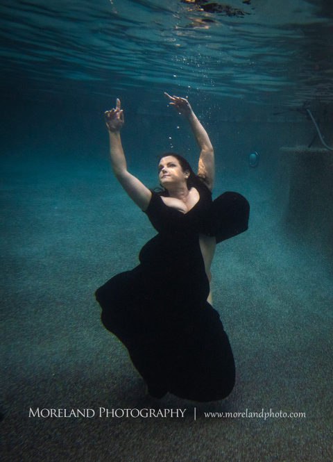 Woman reaching for the surface in black dress underwater, underwater portraits, creative photography atlanta,established underwater photography company, best underwater portraits, moreland photography, celebration photo shoot, underwater photography, nikon, birmingham underwater photography